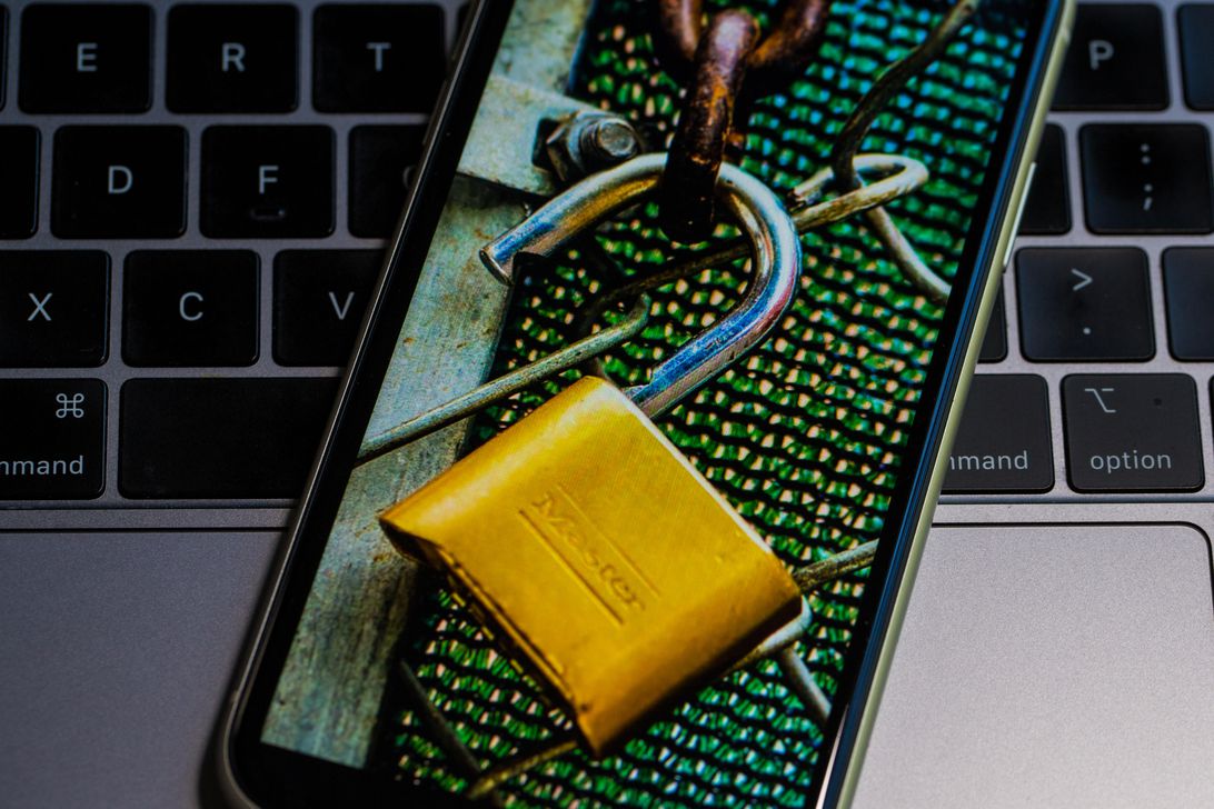 Padlock on smartphone on laptop keyboard