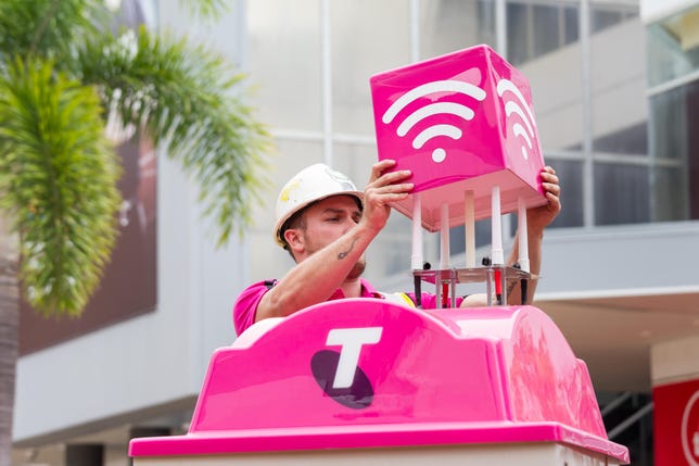 A Telstra technician installs a 5G-capable public Wi-Fi hotspot