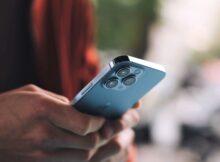 A person holding a blue iPhone 13 in both hands