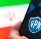 Hand holding a smartphone with a VPN logo on screen, the Iran