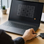 Conceptual office scene showing an administrator disconnecting a backup drive beside a laptop.