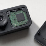Conceptual opened dashboard camera showing its circuit board and processor on an inspection bench.